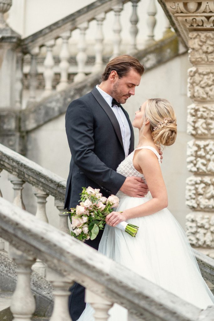 Bride holding bouquet and groom on Chiswick House steps