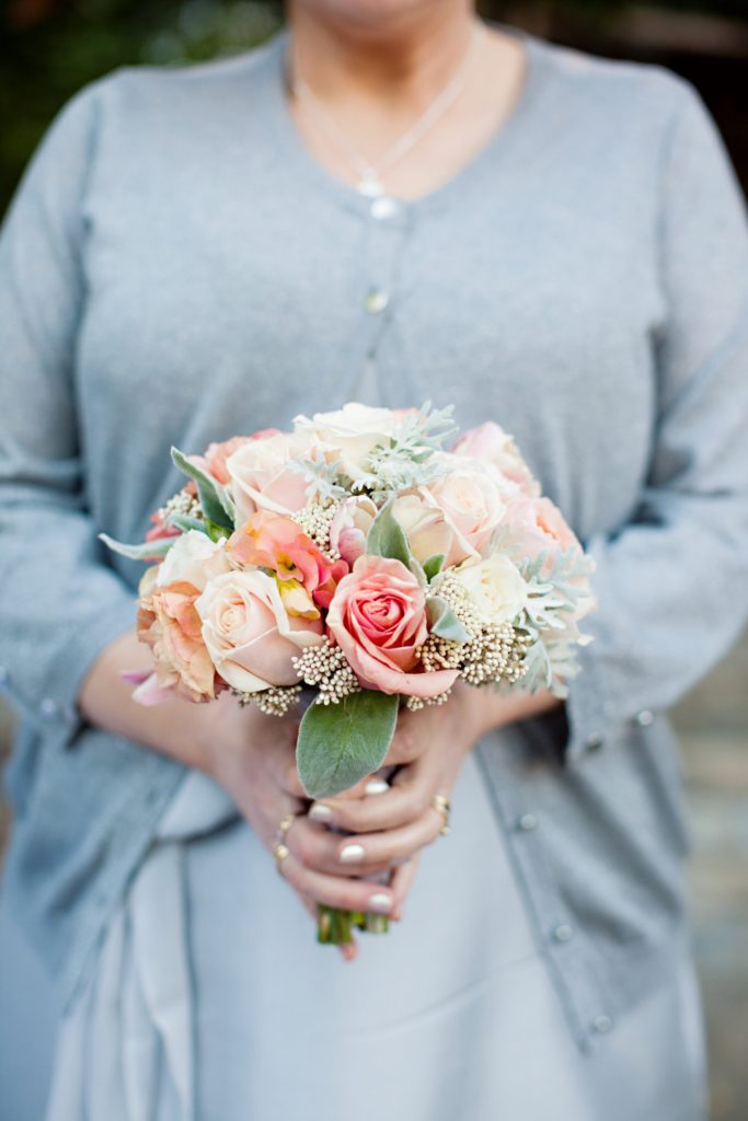 Bridesmaid in grey holding blush bouquet