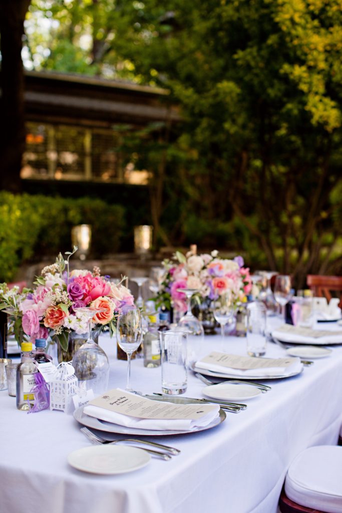 Long wedding table with blush and coral flower centrepieces
