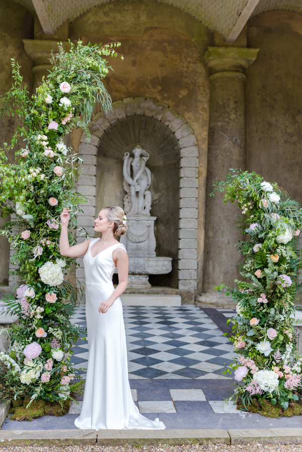 Asymmetrical flower ceremony arch using roses and pale pink flowers at Wotton House