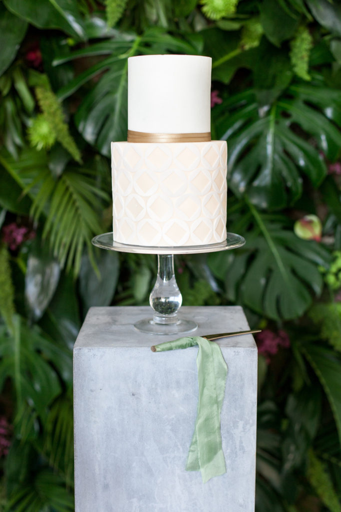 2 tier white wedding cake with sage green ribbon