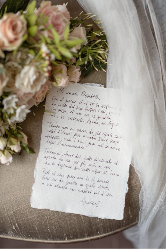 Handwritten love letter on deckled edge paper with flower bouquet and veil