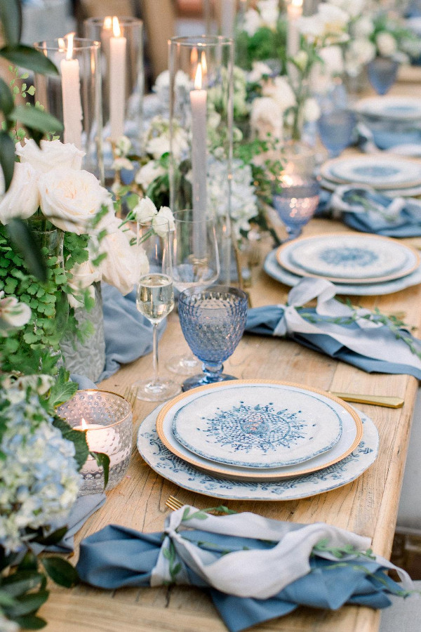 Wedding reception table using blue glassware, blue linens and crockery