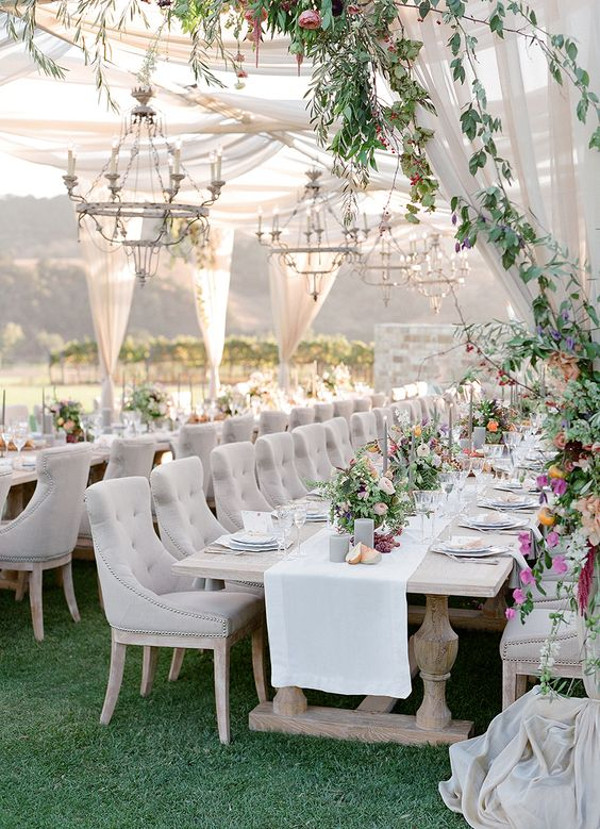 outdoor wedding reception with chiffon draping overhead and chandeliers