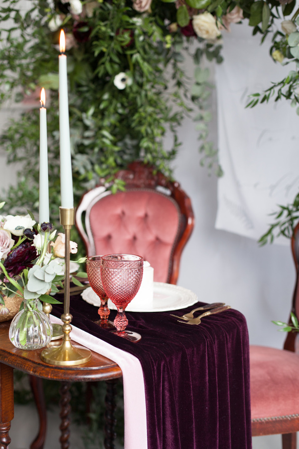 wedding reception sweetheart table with velvet runner and velvet chairs