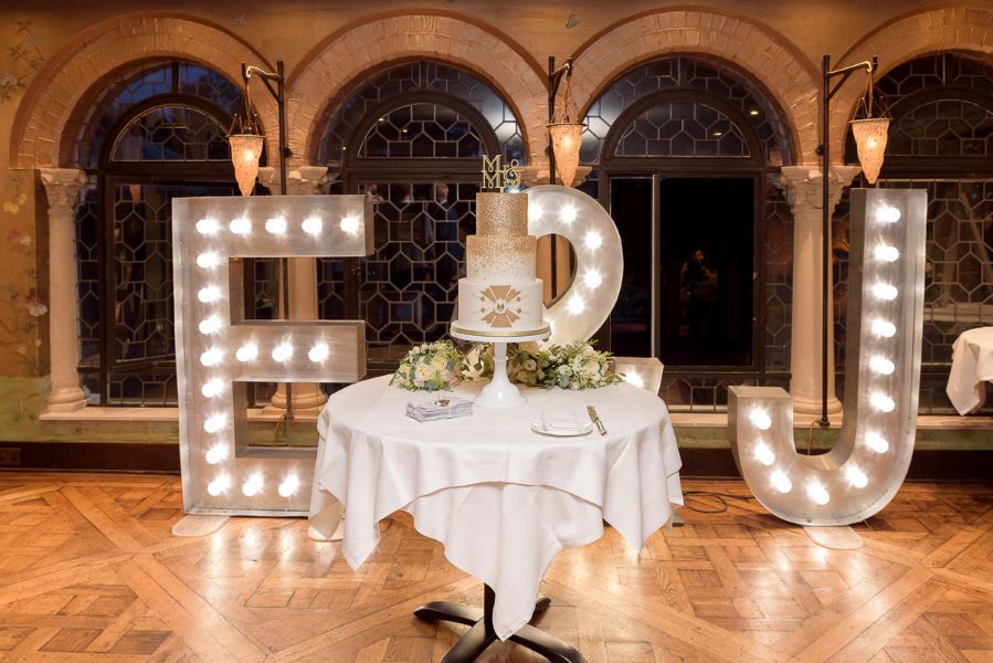 Light up letters with wedding cake table and flowers