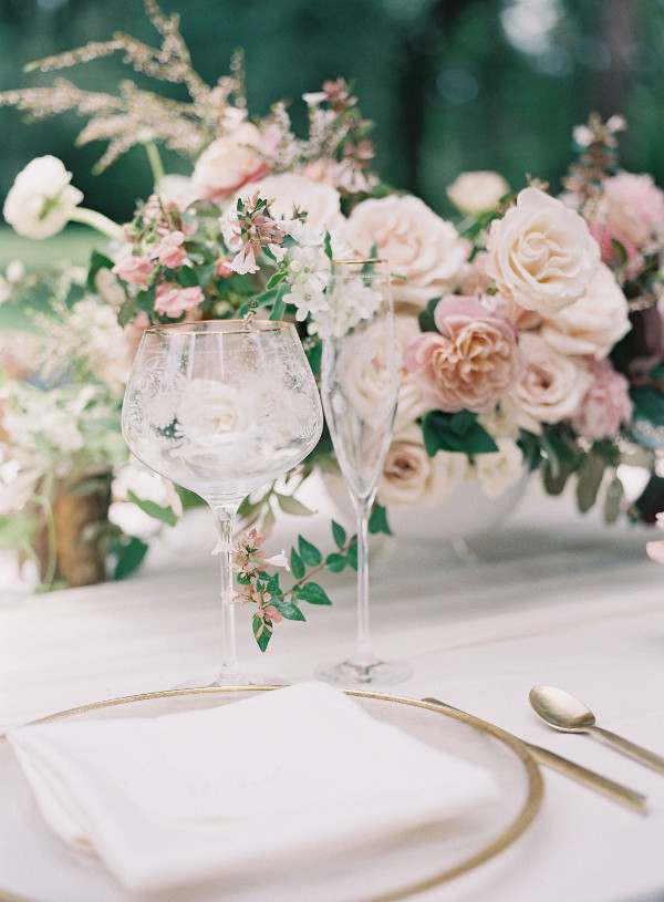 Wedding table with glassared, gold chargers and cutlery and blush and pink flower centrepieces