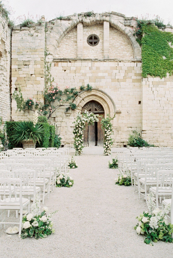 Outdoor wedding ceremony with flower arch and aisle meadow flowers