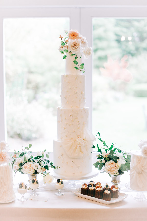 4 tier wedding cake with fresh flowers and bow detailing