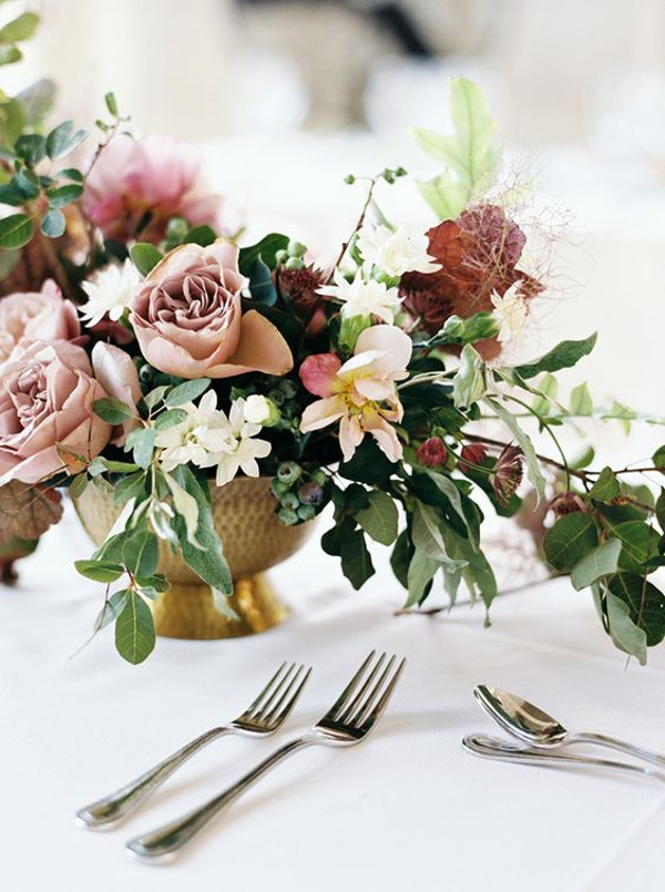 Wedding table centrepiece in a bronze vase with shades of blush, burgundy