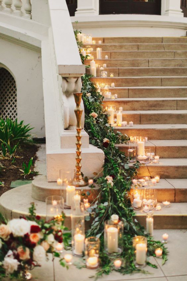 Greenery garland sweeting down a candlelit staircase
