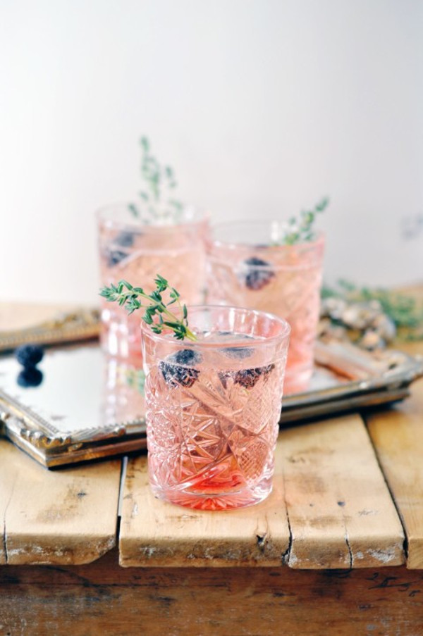Blackberry and champagne cocktail in crystal glass, with thyme and blackberry garnish