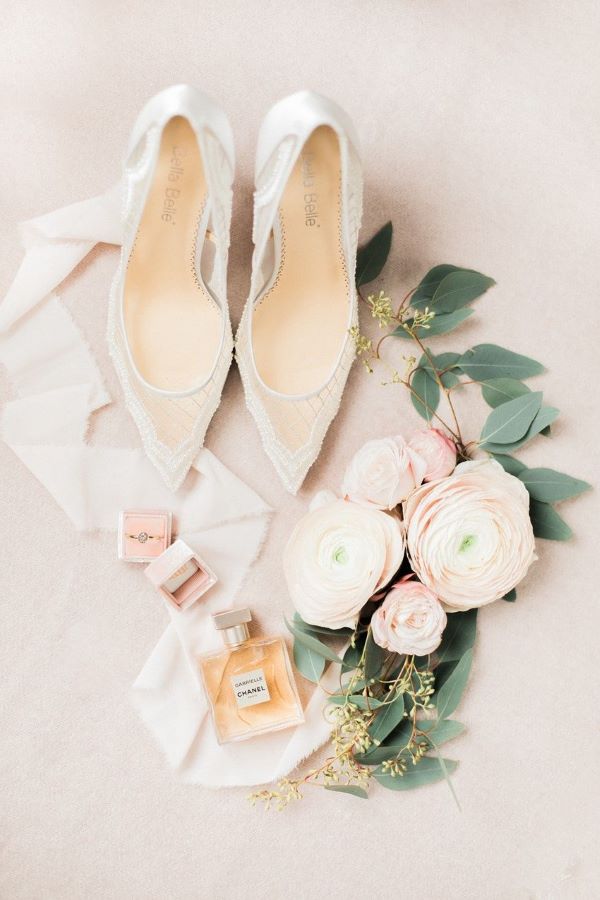Flat lay with wedding shoes, peonies, Chanel perfume and wedding rings
