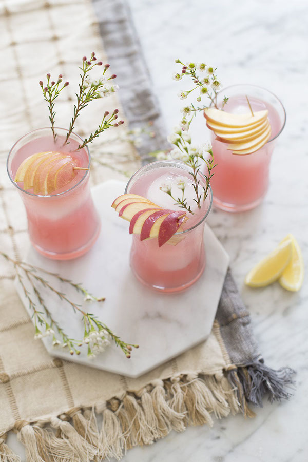 Elderflower gin cocktail in highball glasses with apple garnish