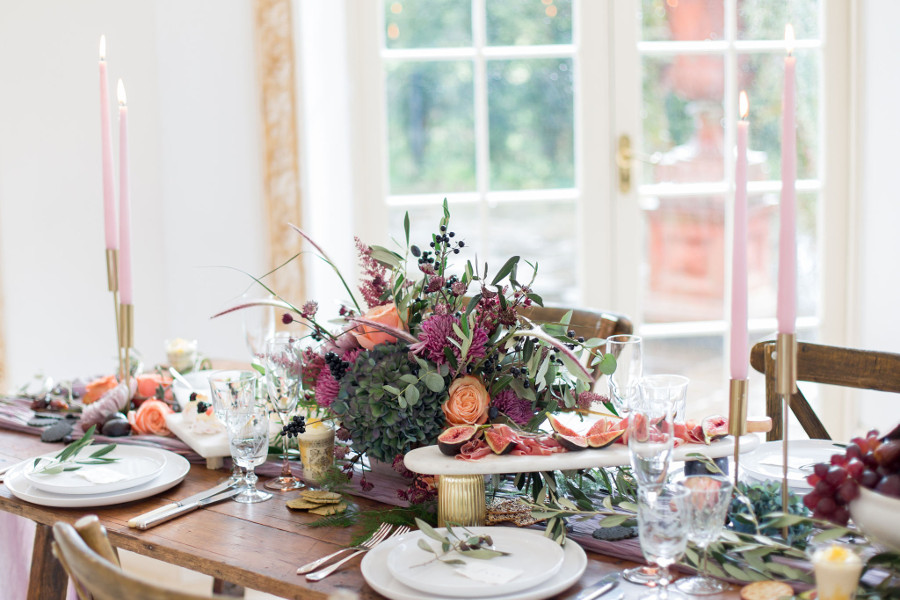 Table set with glassware, candles and grazing platters