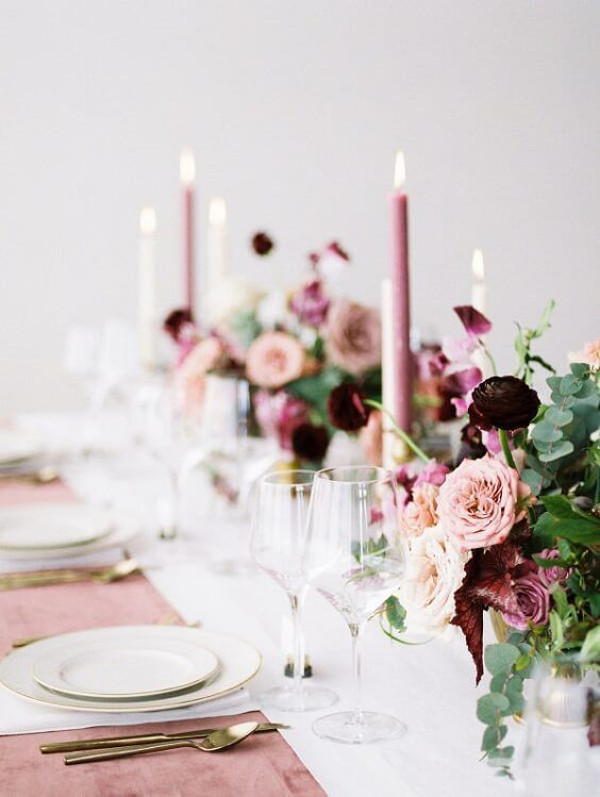 Wedding table set with plates, cutlery and blush and burgundy flowers