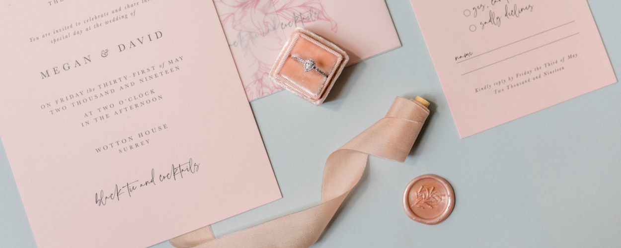 Blush stationery suite with engagement ring and ribbon
