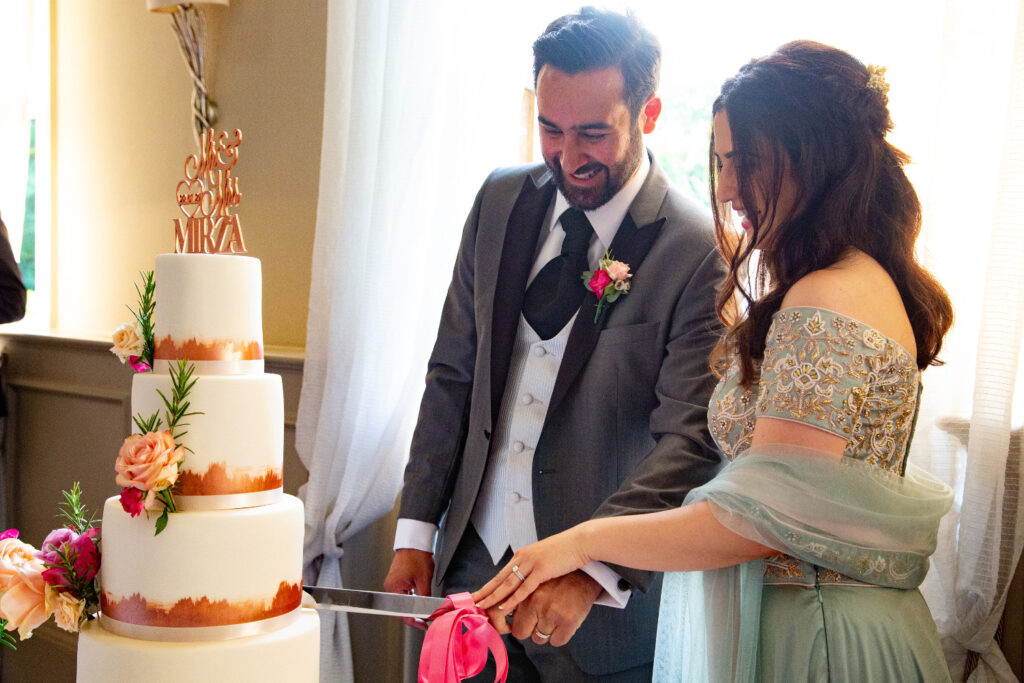 Couple cutting cake at Persian wedding Morden Hall