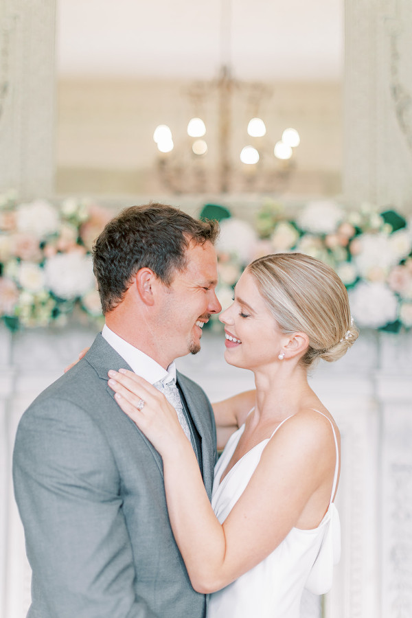 Wedding couple in front of flower installation on fire place