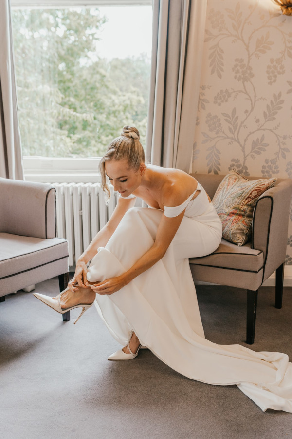 Bride putting shoes on