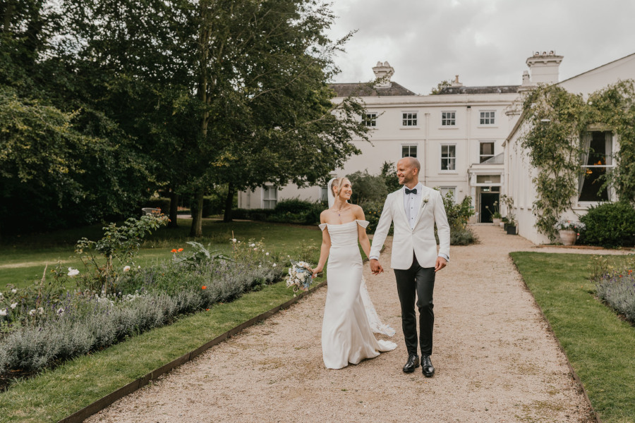 Bride and groom holding hands outside Morden Hall wedding venue London