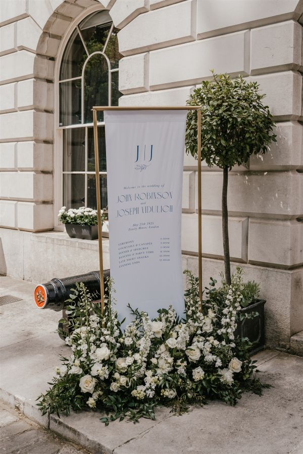 Monogrammed fabric welcome sign with floral installation