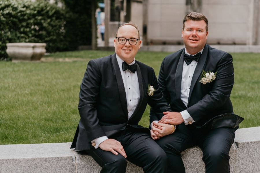 Two grooms sitting outside Four Seasons London