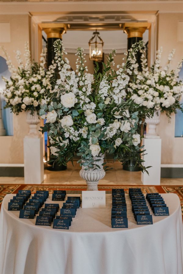 Escort card table display with white flower arrangement
