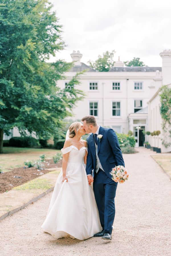 Bride and Groom kissing outside Morden hall london