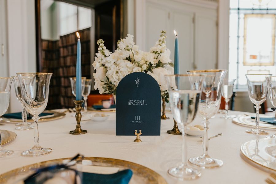 Wedding table name in navy blue with candles and flowers
