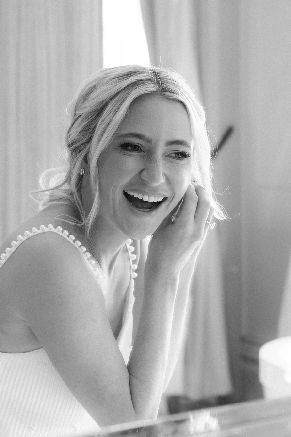Bride putting on earrings