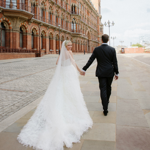 Bride and grooms walking outside London St Pancras Hotel